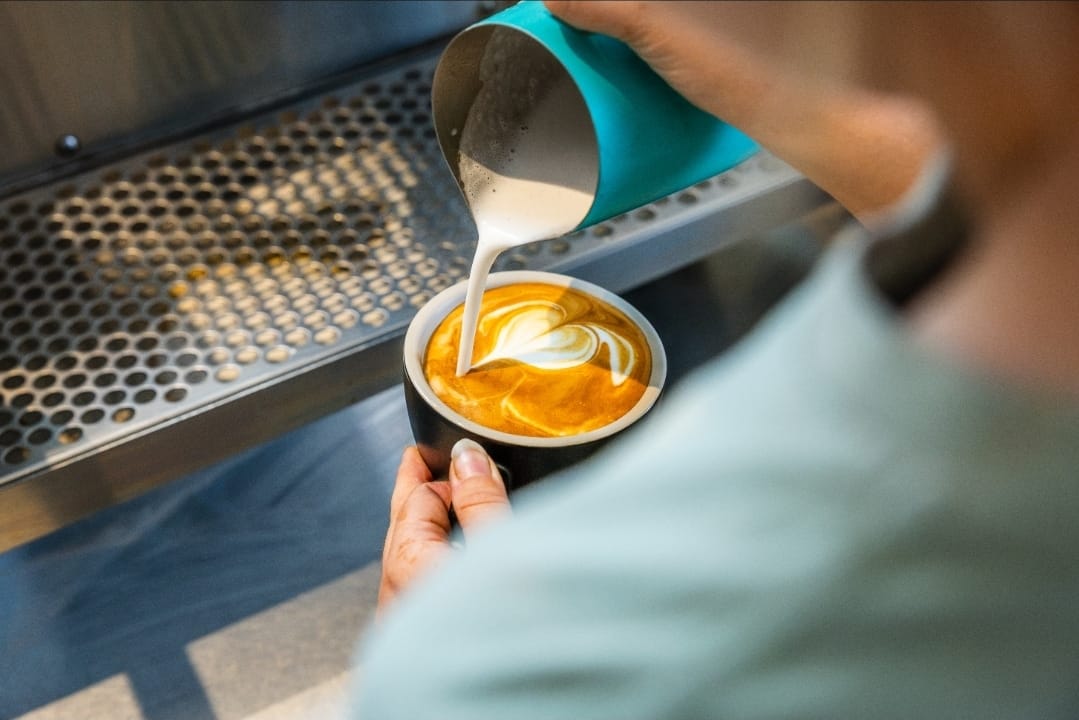 Barista pouring latte art at The Eve