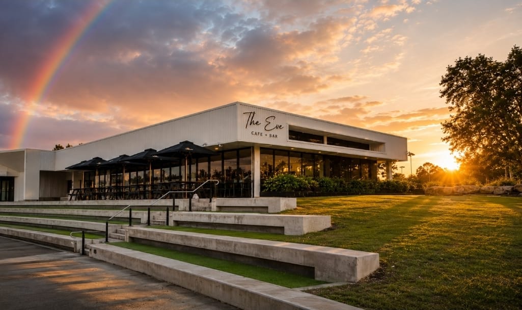 The Eve Cafe + Bar exterior at sunset with a rainbow over Greenbank