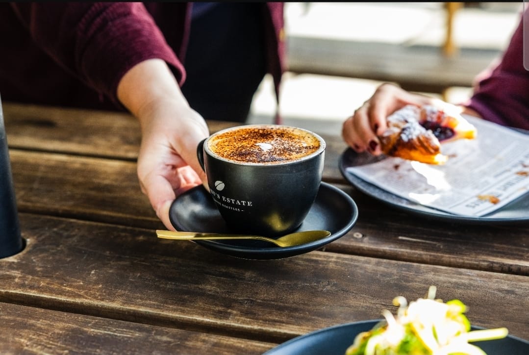 Cappuccino and pastry served on a timber table